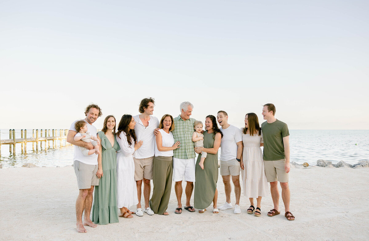 A multi-generational family gathers for a beach group portrait during a Florida Keys family session. Claudia Amalia, Florida Keys portrait photographer.