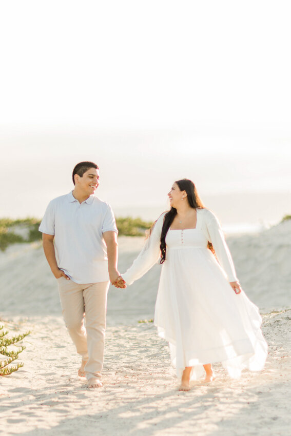 engaged-couple-walking-in-dunes-Coronado-San-Diego