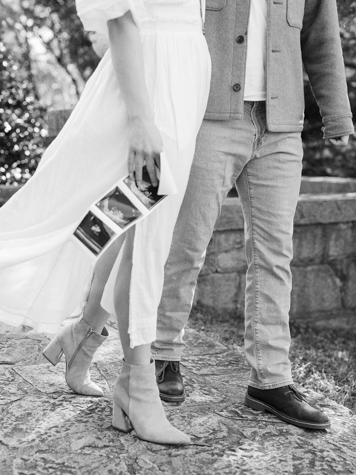 A close-up of a couple walking with the woman holding a sonogram at a Richmond maternity photography session by Katie Stansfield Photography.