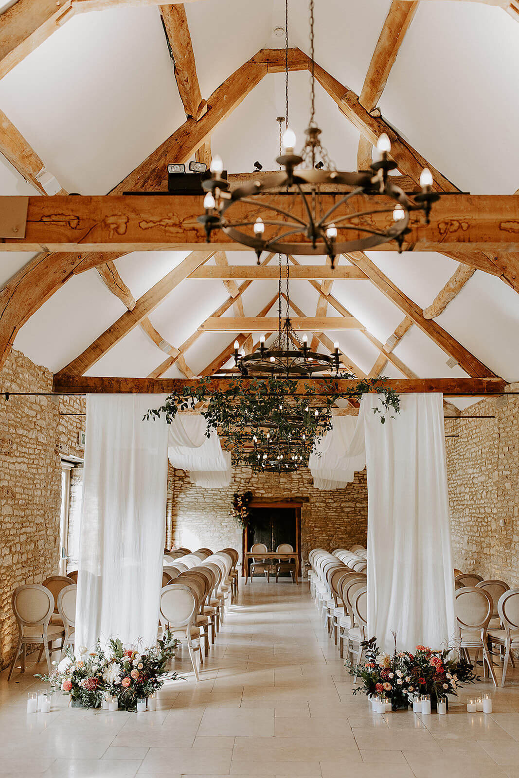 Barn reception space at Caswell House styled with soft drapery across the beams