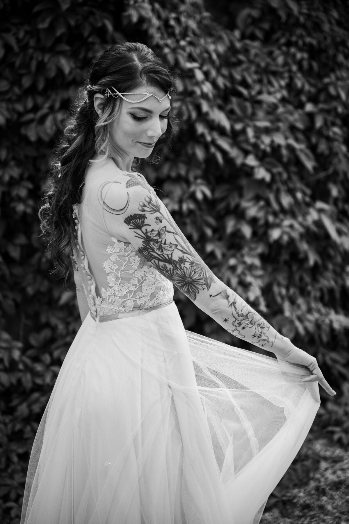 A bride with a sleeve of tattoos twirls her dress, captured by Colorado wedding photographer, Casey Van Horn.