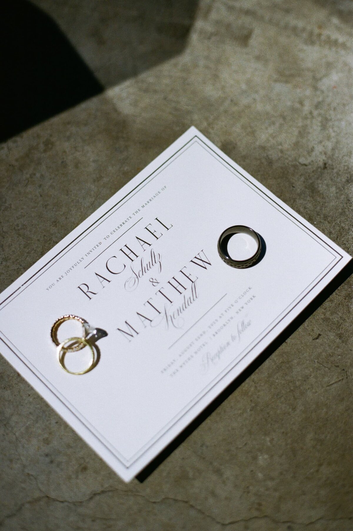 wedding invitation and rings shot in film at the suite of the wythe hotel