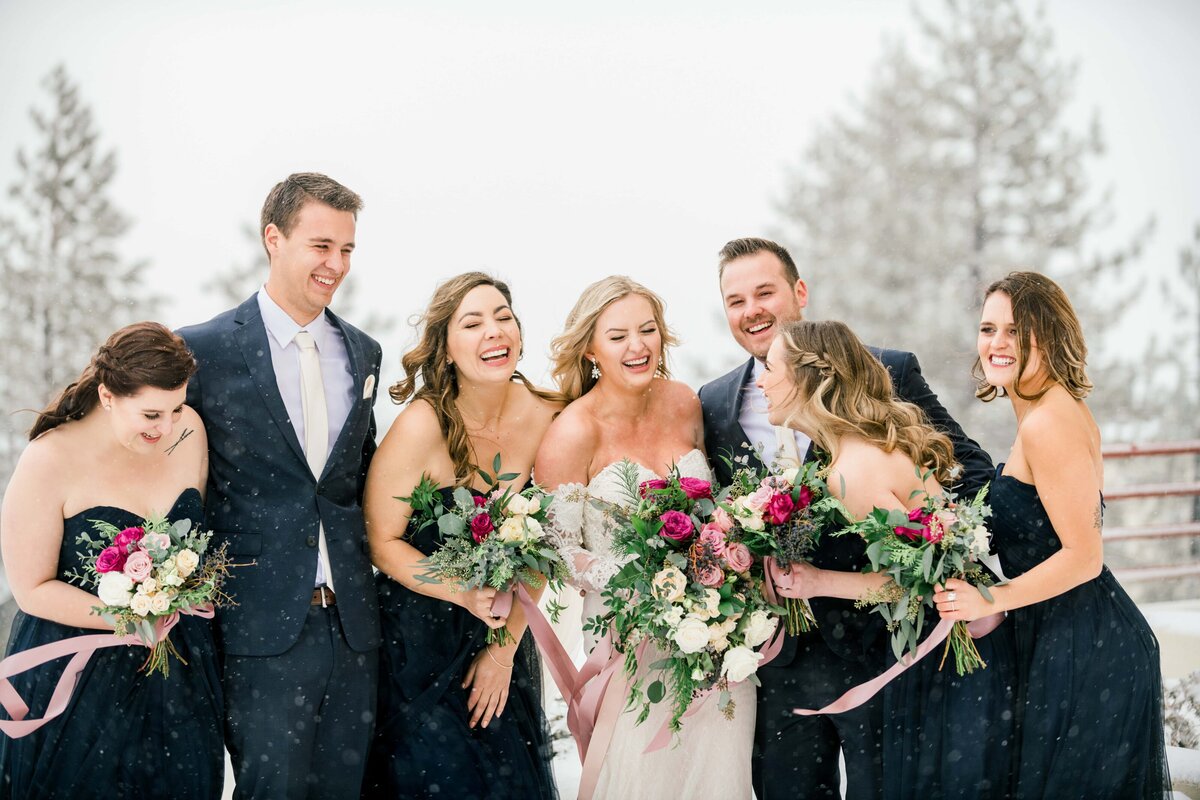 Wedding party laughing in snow