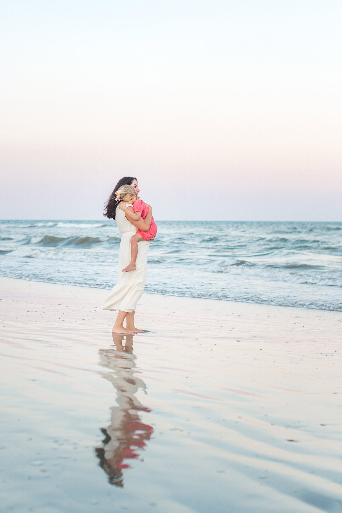 Mother and daughter embrace on Charleston beach by Karen Schanely