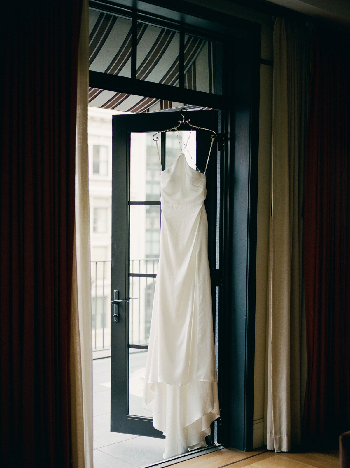 Jenny Yoo silk pearl back wedding dress hangs at Shinola Hotel, Detroit