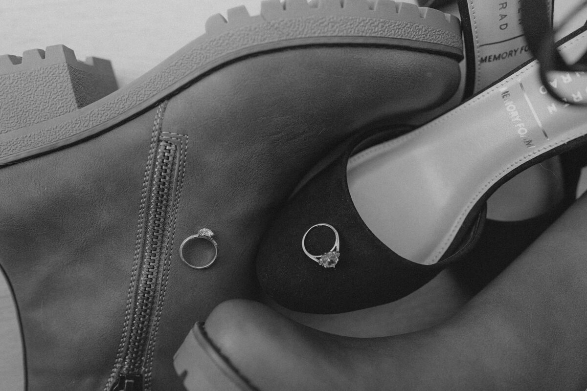 Wedding bands rest atop wedding shoes