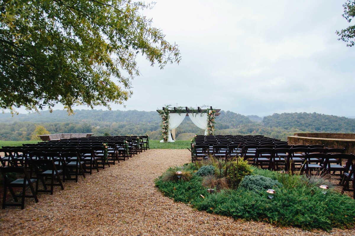 View of decorated ceremony with arbor in background at chateau selah