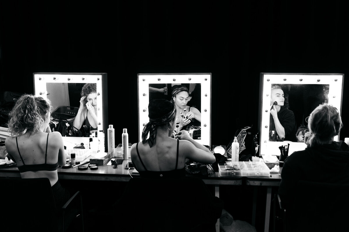 Drie actrices maken zich op voor drie losse theaterspiegels.