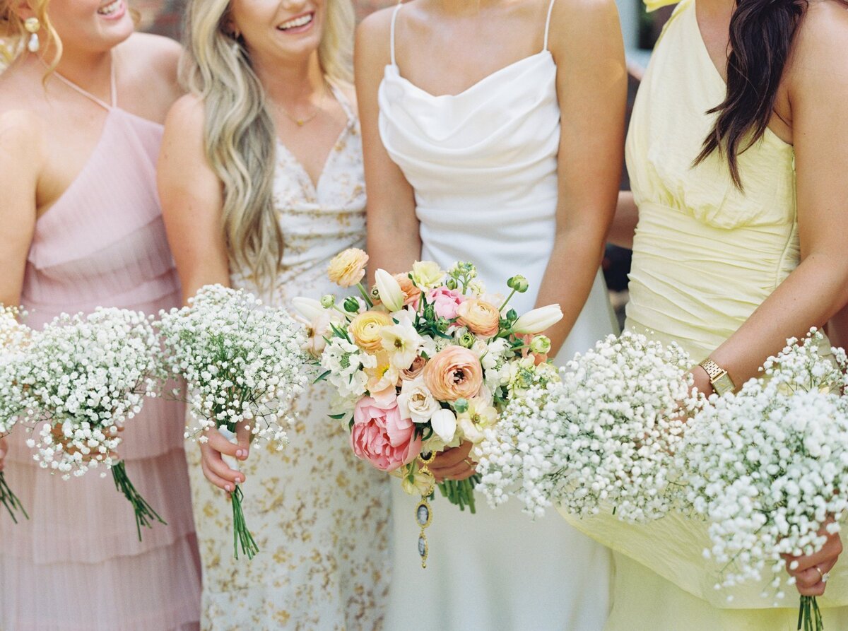 Bridesmaids in vibrant spring dresses holding colorful bouquets, captured on film by Morgan Alysse, Louisiana film photographer.