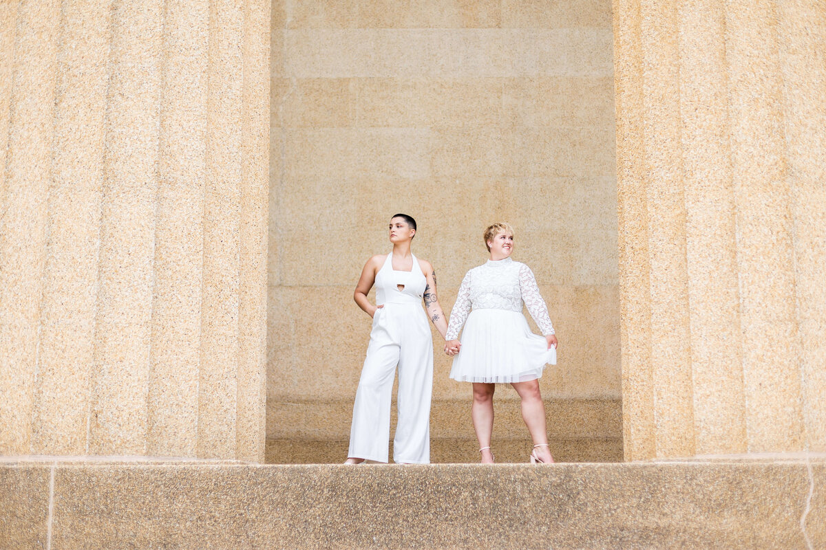 Woman wearing white jumpsuit with woman wearing white dress at LGTBQ wedding in Centennial Park, Nashville,TN