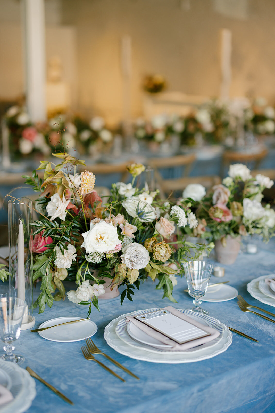 Fall reception table floral arrangements in colors of mauve, cream, dusty rose, dusty blue, taupe, and natural green. Autumn floral consisting of roses, rain tree pods, fall branches, clematis, and greenery. North Carolina wedding design by Rosemary and Finch floral design based in Nashville, TN.