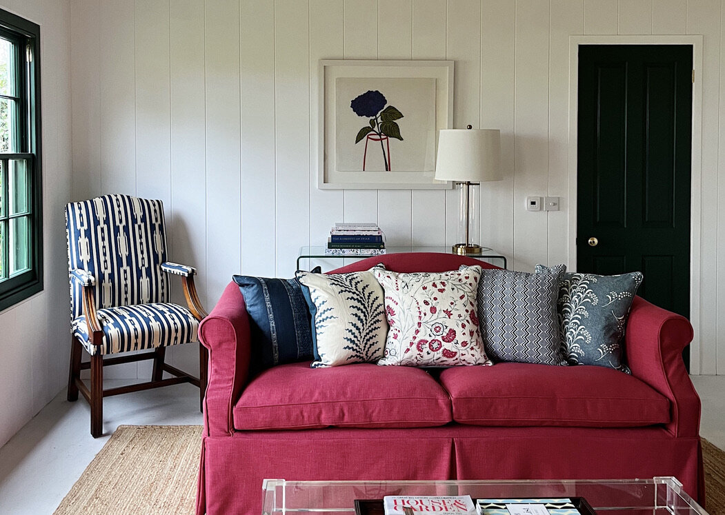 Alexandra Langdon Interiors Garden Room with cherry red linen sofa, tongue & groove paneling and Pooky Lighting lamp.