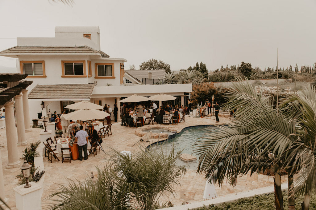 Guests mingling during cocktail hour at a backyard wedding venue