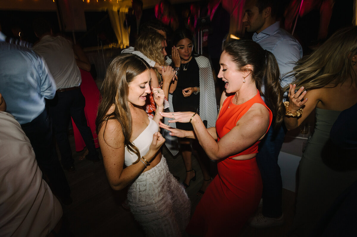 Bride wearing a two-piece outfit and her sister dancing