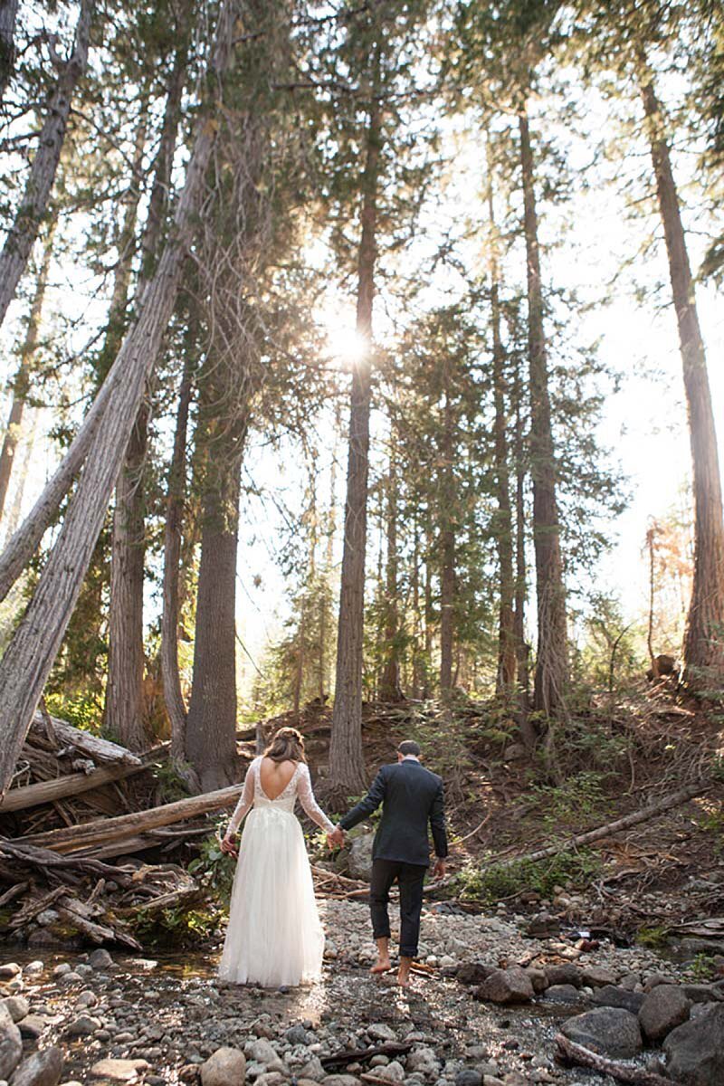 Woodsy forest backdrop with newlyweds walking on rocks