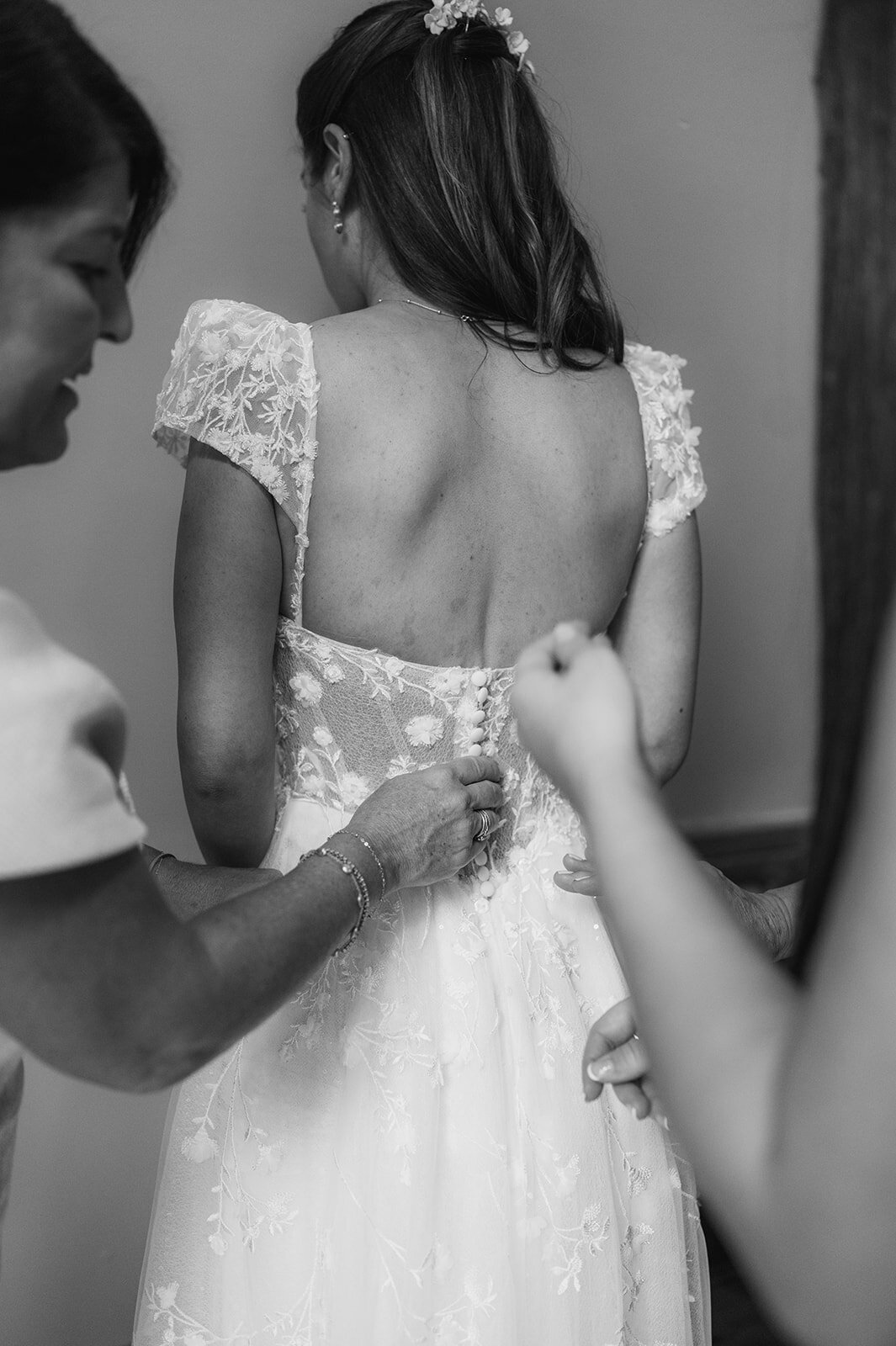 detail shot of bride getting dress buttoned