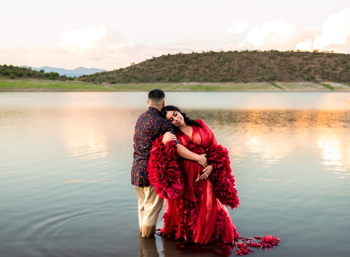 Expecting wife and husband standing in water for maternity session in Arizona lake