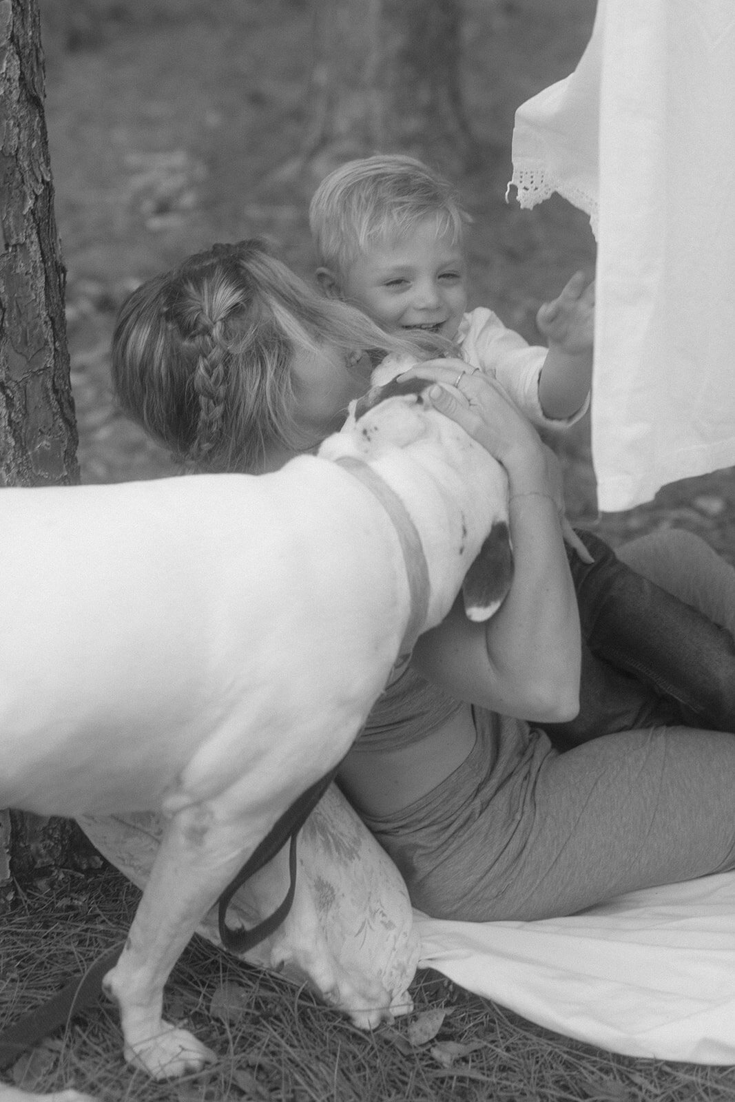 Mother and son playing with dog outside
