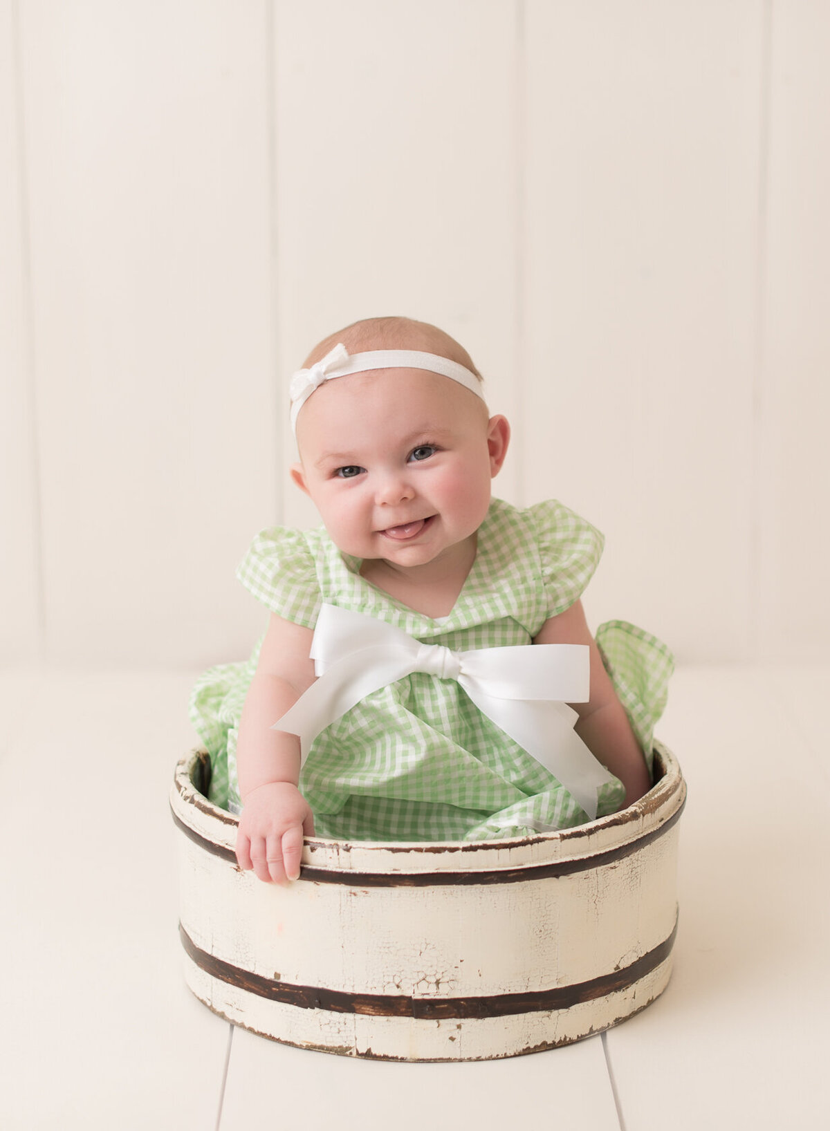 Smiling baby in green dress and bucket  photo session in Houston