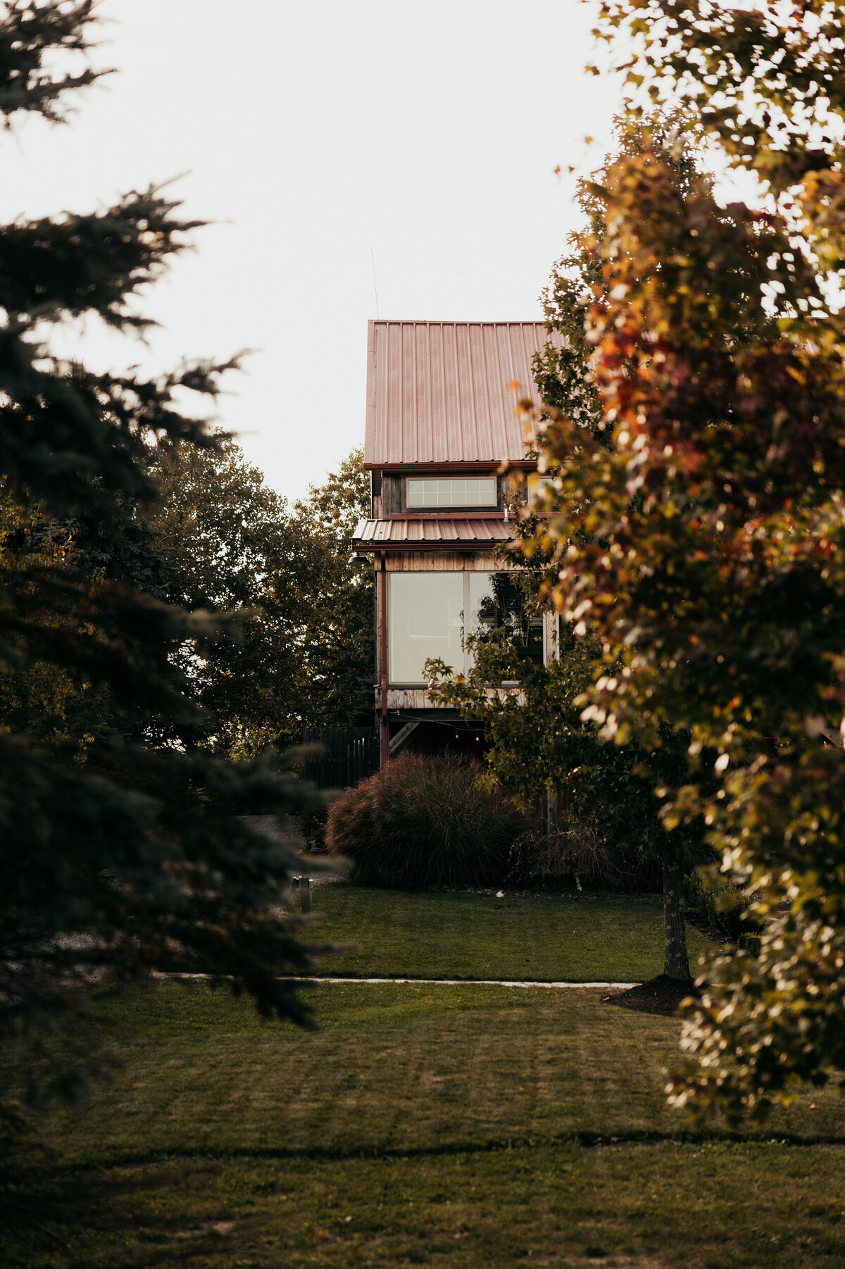 the side lawn view of the exterior of Willowbrook wedding venue modern event barn with Fall trees