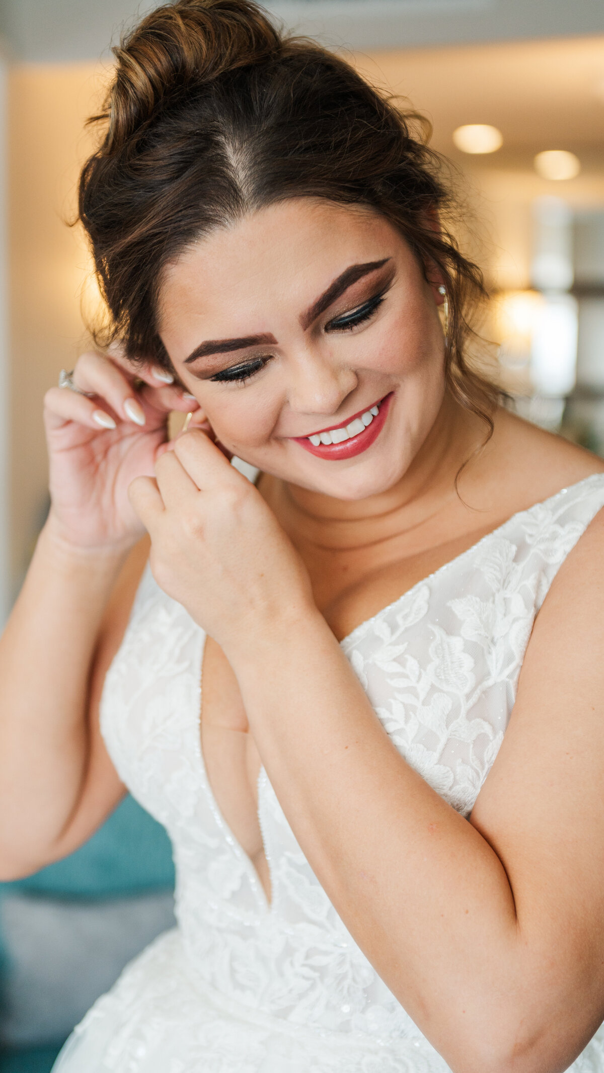 bride putting on her jewlery during her wedding day