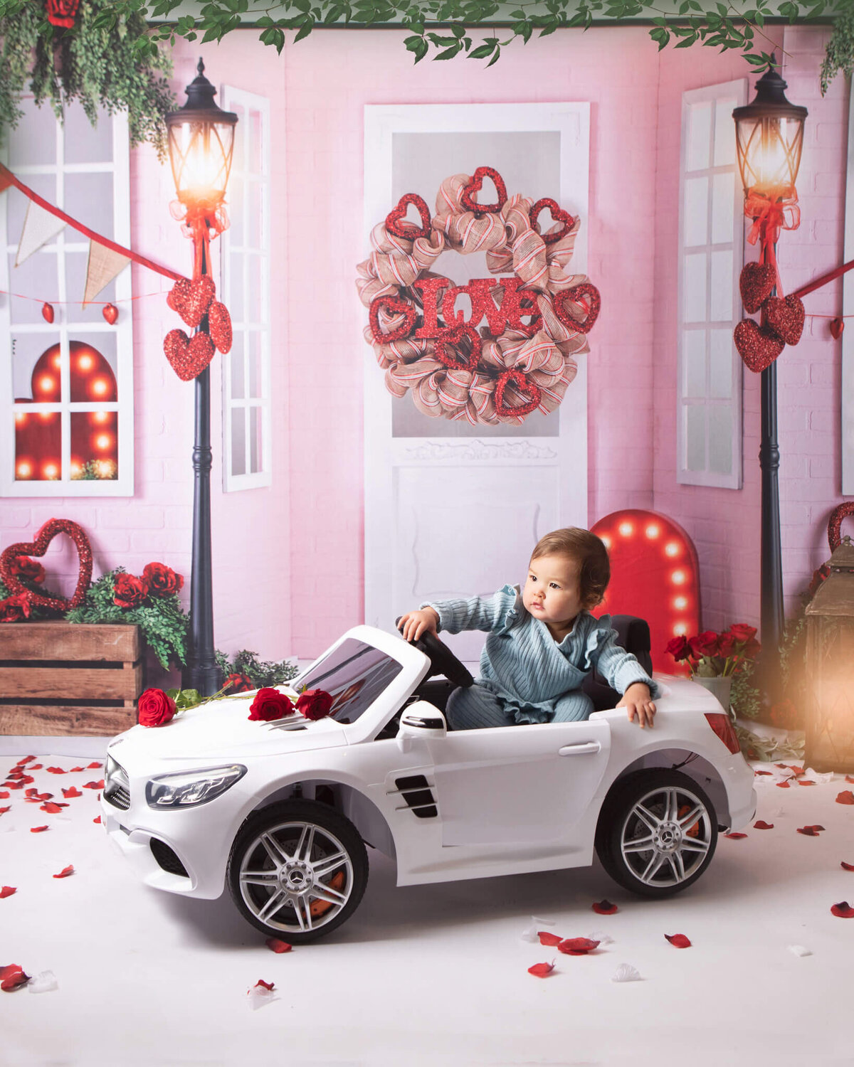 Valentines Day photoshoot with baby girl sitting in a baby car