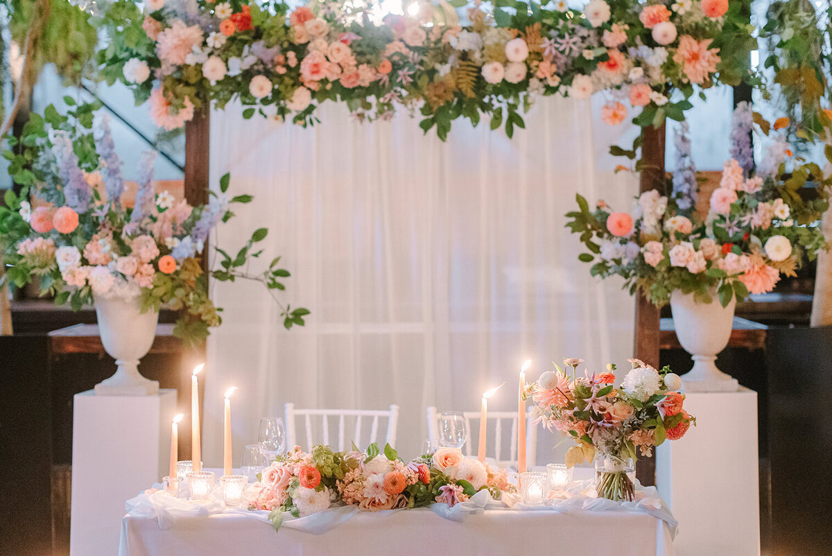 A sweetheart table at Restaurant Richmond is decorated with suspended flowers and large colourful arrangements.