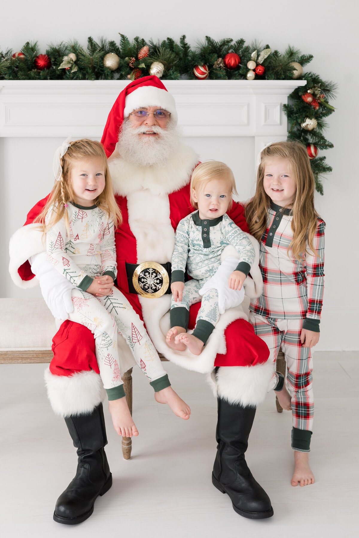 3 siblings taking a photo with Santa