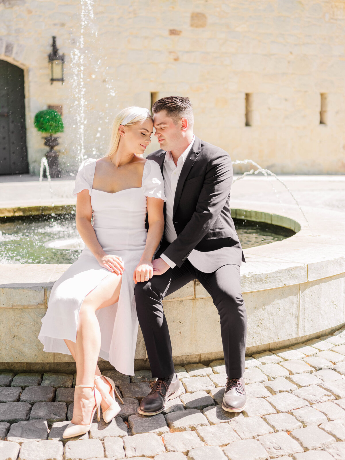 Wedding couple sitting at a fountain