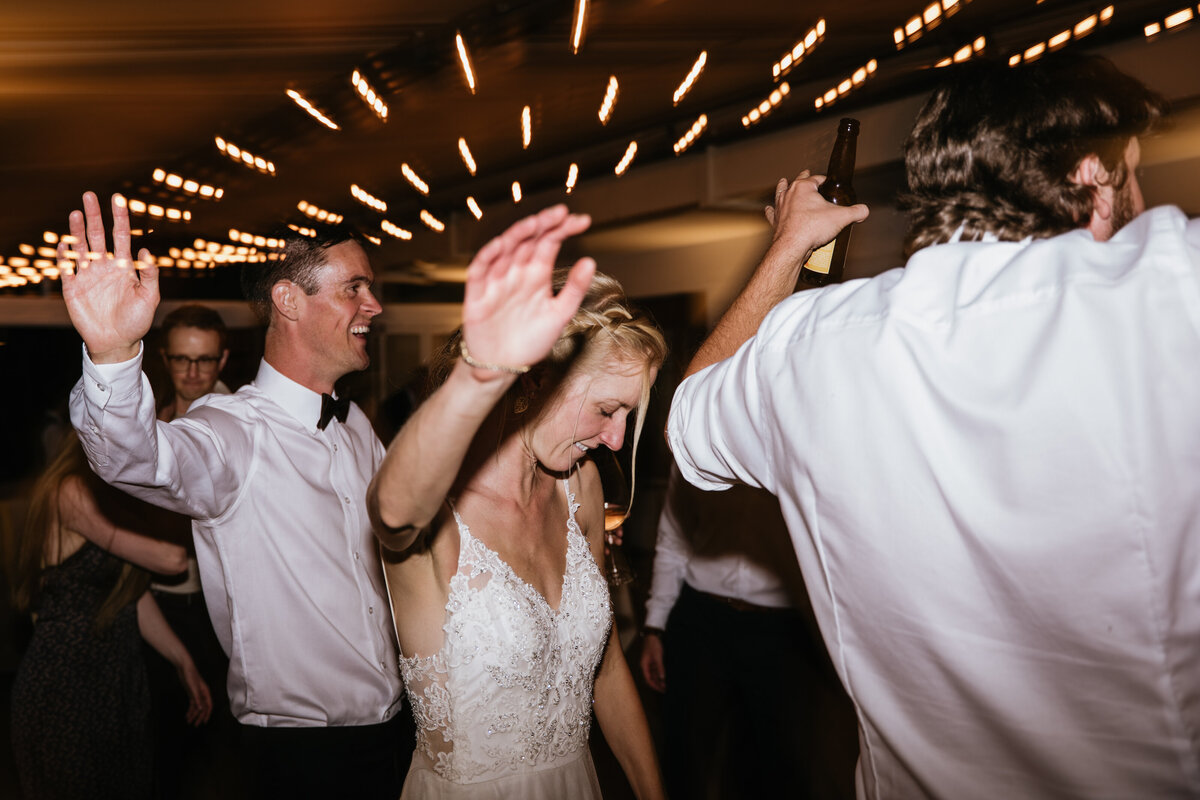 Friends dancing together at indoor wedding party