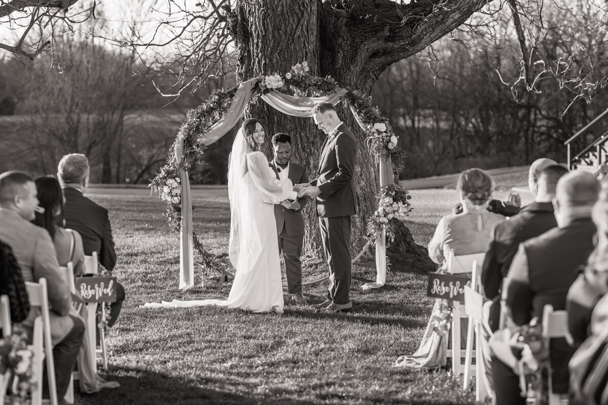 Bride and groom share a laugh during their outdoor wedding ceremony