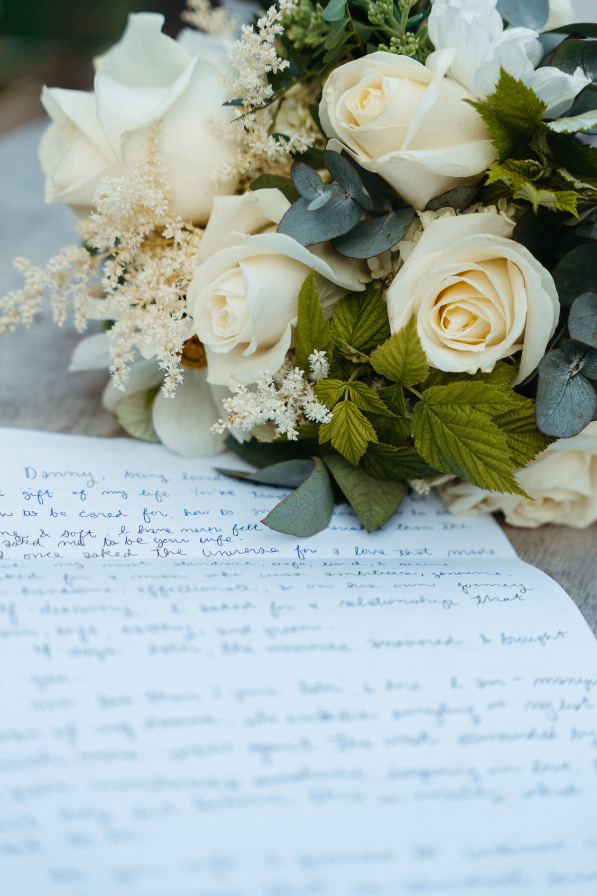 Handwritten wedding vows with flowers on rustic table