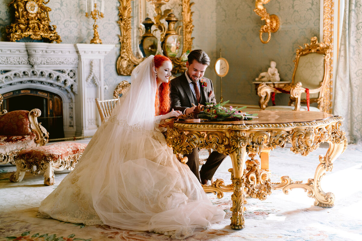 couple signing the register at at allerton castle in the drawing room