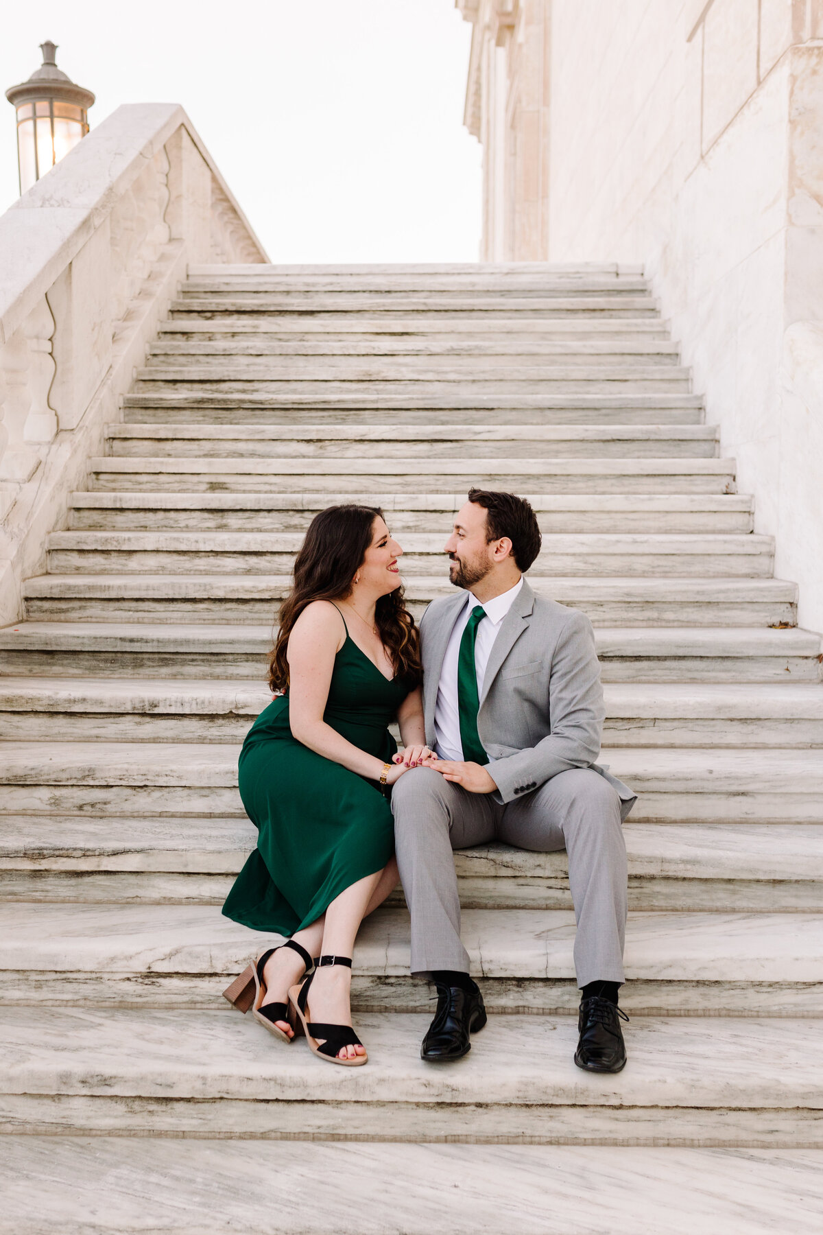 man and woman sitting on stairs looking at each other