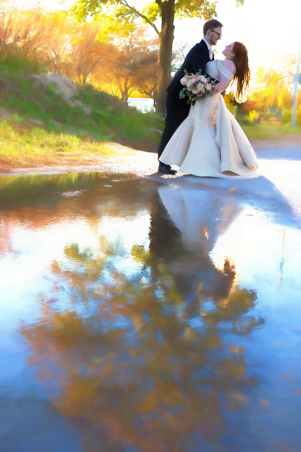 A bride and groom are kissing in a puddle of water