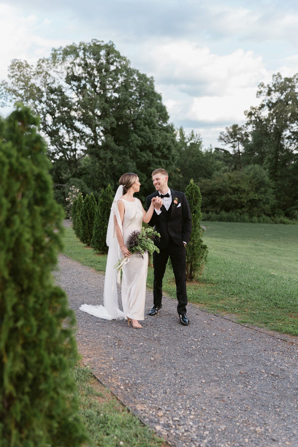 Bride and groom laugh as they walk holding hands at Montaluce Winery wedding venue.