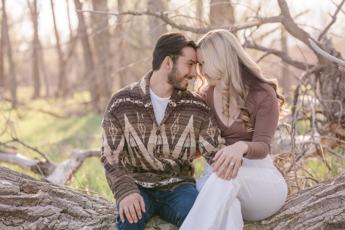 An engaged couple smile shyly during their Boulder Engagement Photography session at Walden Pond