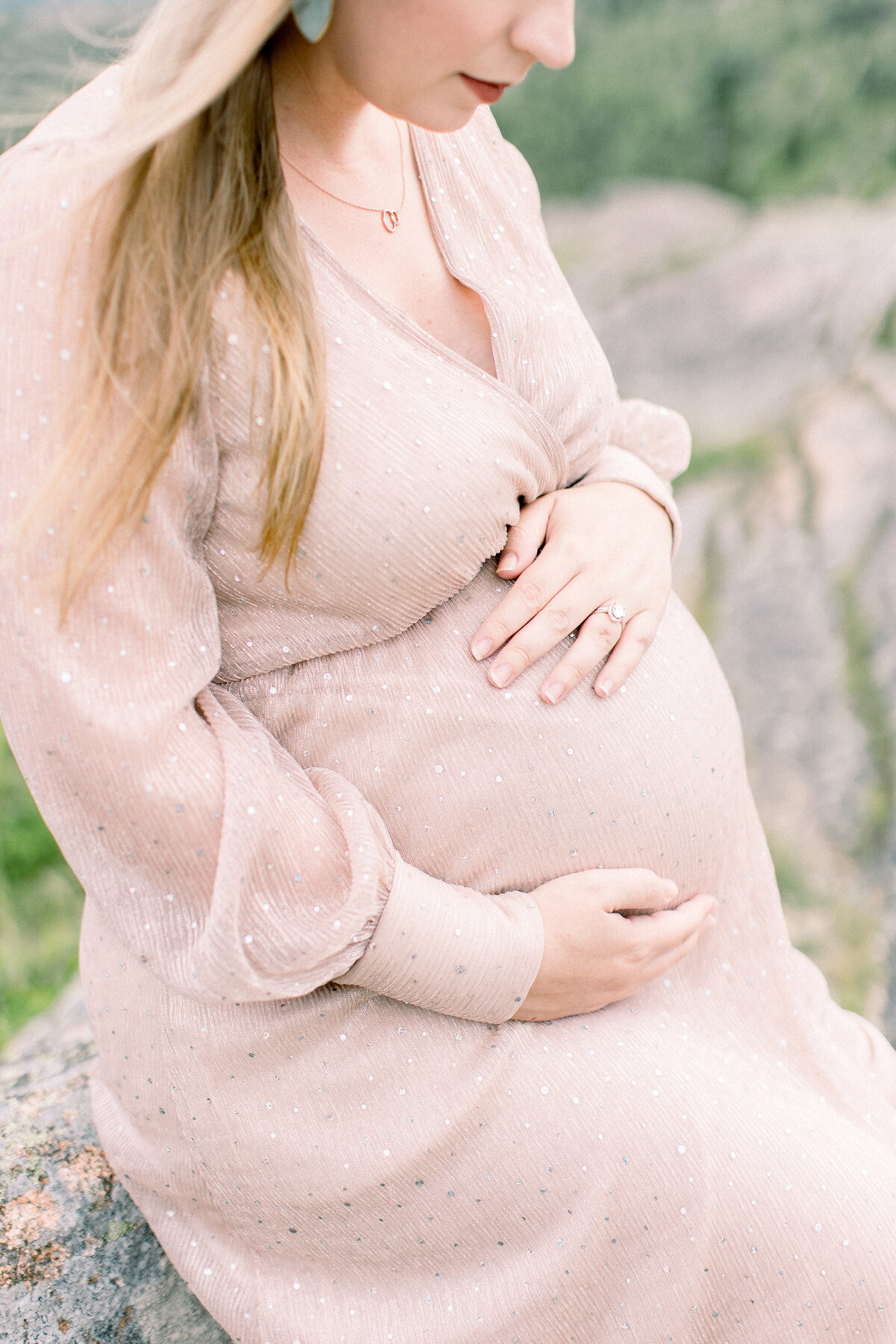 Closeup of mother's baby bump in a shimmering champagne gown, with hand softly resting on bump, by Wellesley, MA maternity photographer Fieldstone Studio.