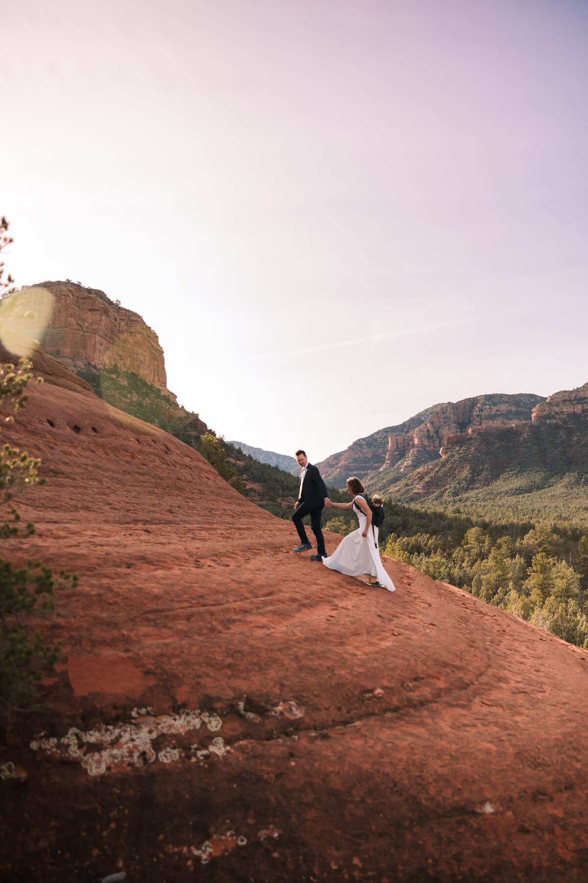 sedona-elopement-walking-holding-hands-up-slope-2