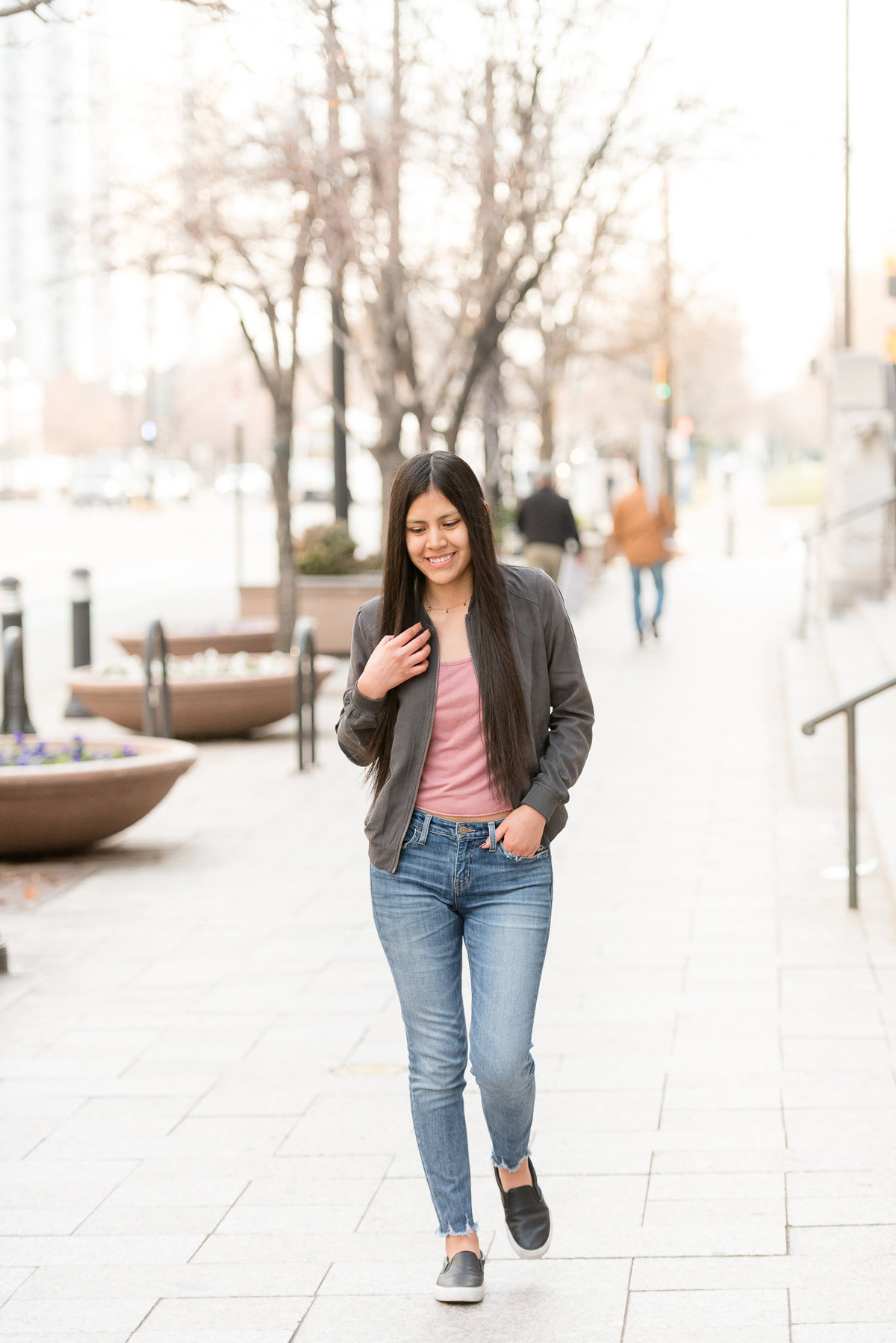 senior girl candidly walks down city street in salt lake