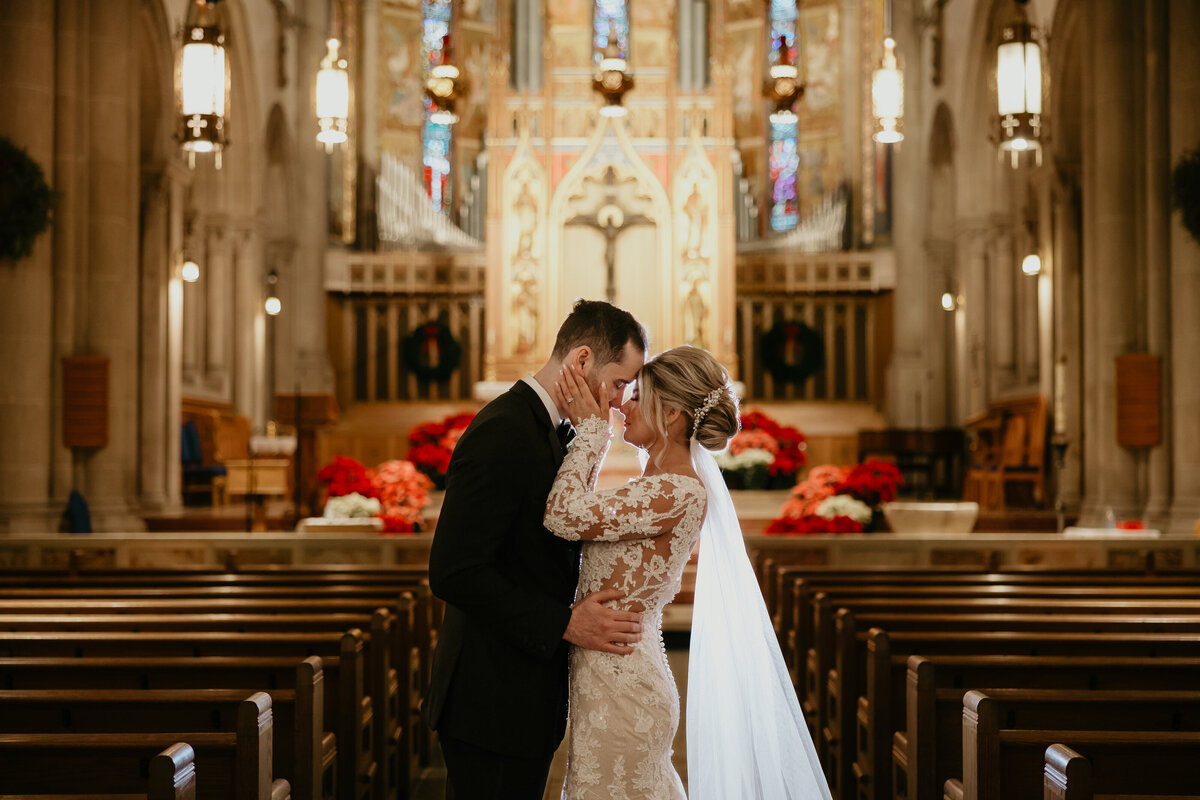 Bride and Groom Kissing in Aisle of Catholic Church after Ceremony