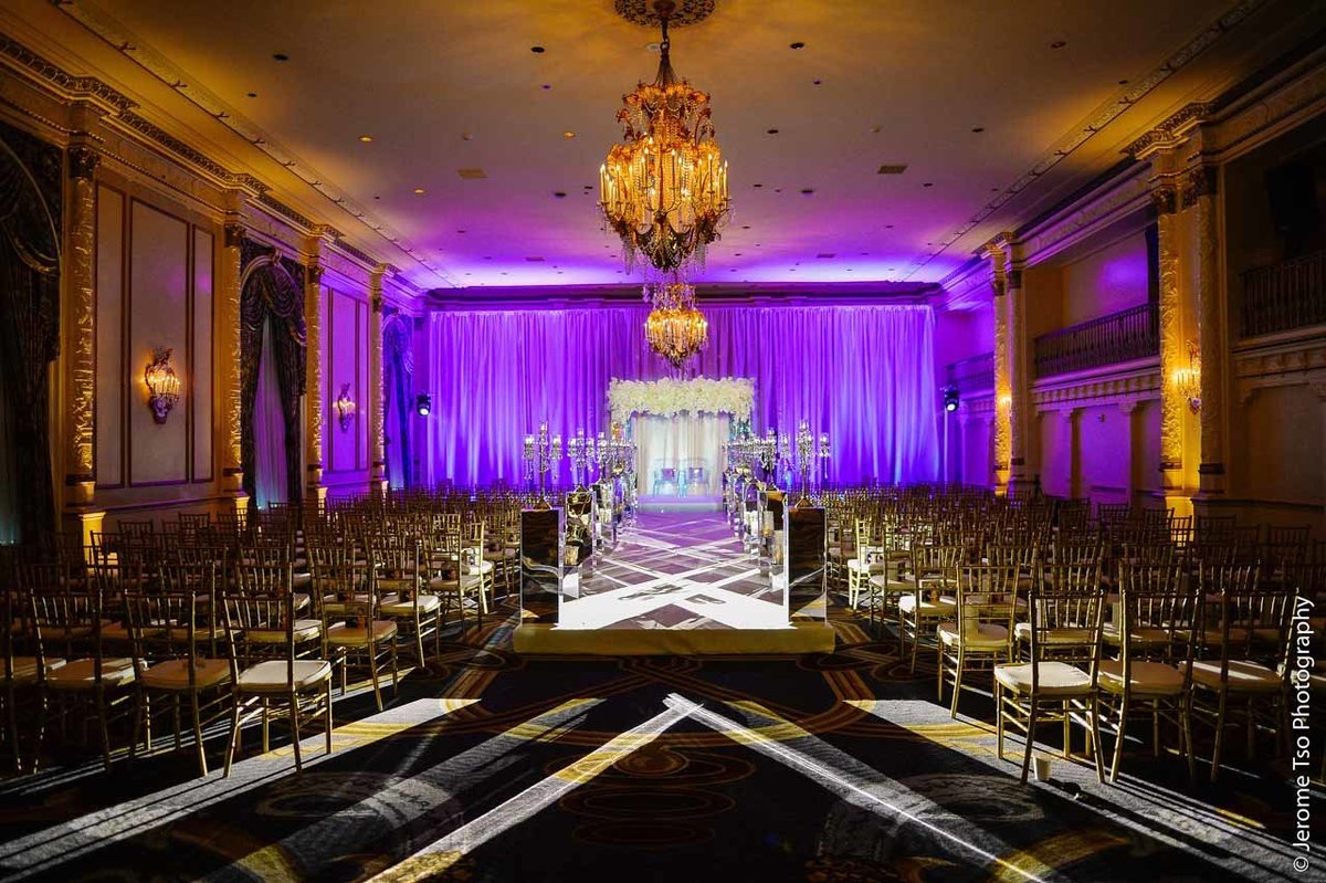 luxury wedding at Fairmont Hotel Seattle with large mirrored wedding arbor, mirrored aisle pedestals, with blue backdrop lighting in St Andrews ballroom