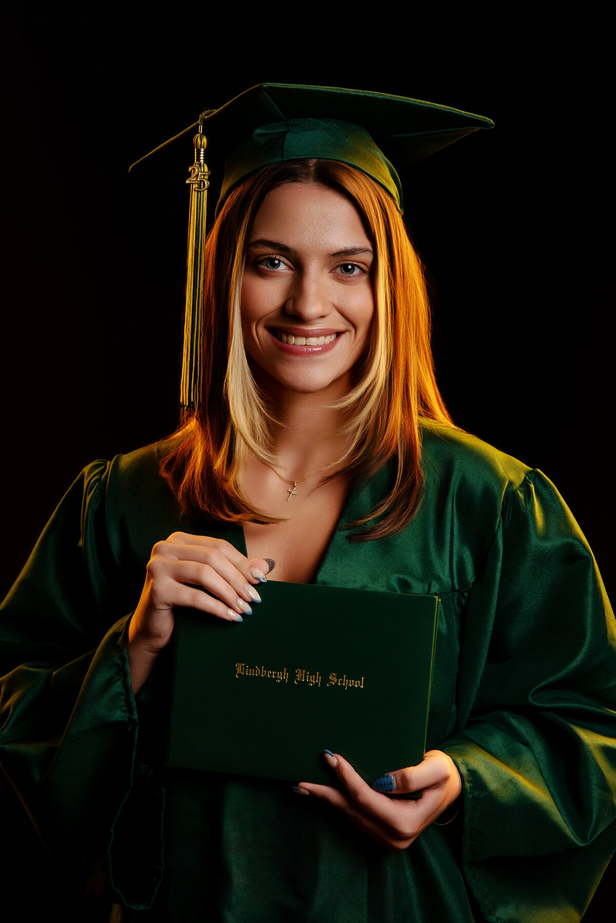st-louis-senior-photographer-senior-girl-in-lindburgh-high-school-cap-and-gown-holding-diploma