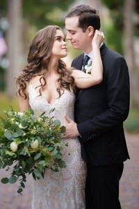 Romantic wedding couple embracing in St Augustine FL, bride in lace gown with bouquet, captured by professional wedding photographer