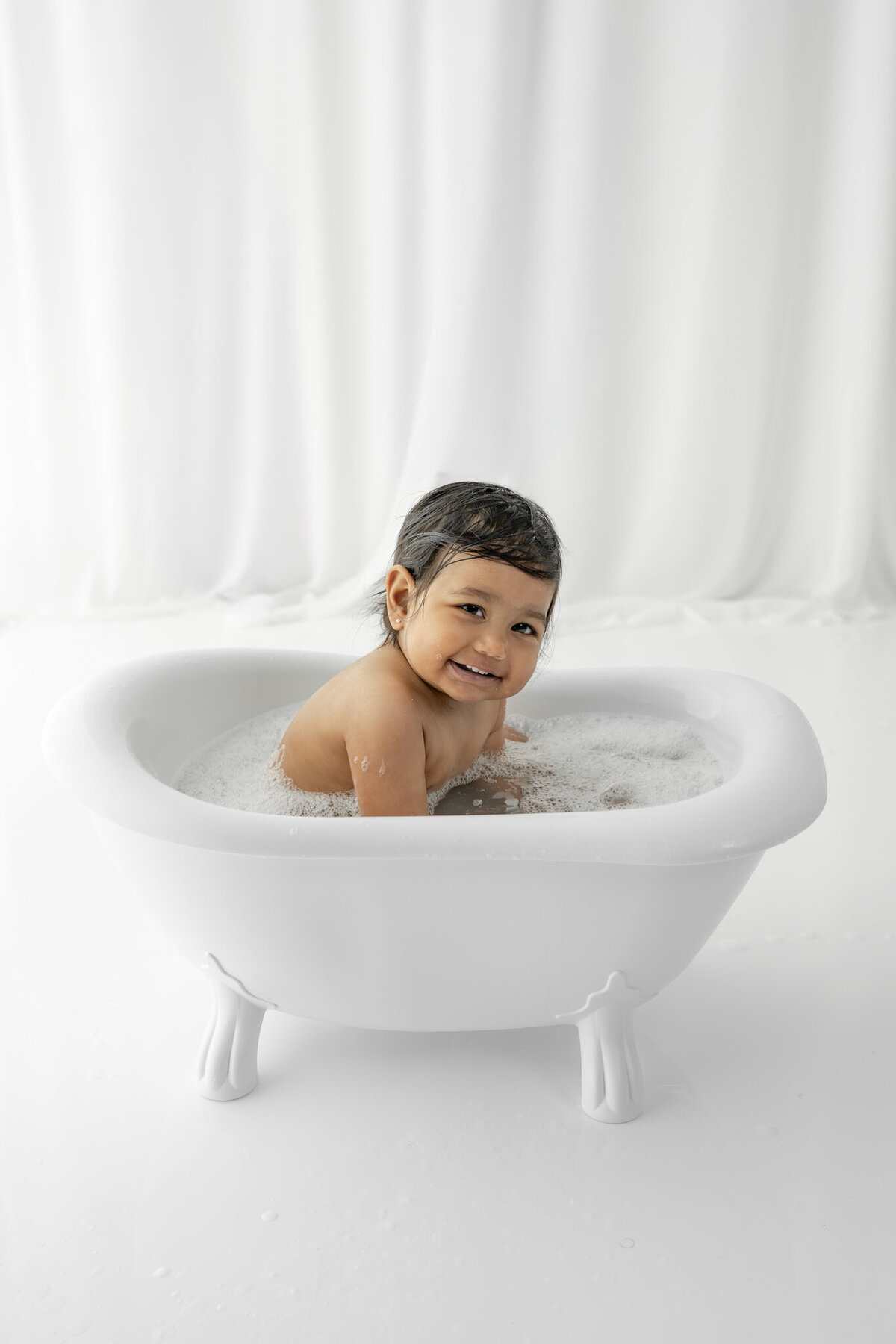Girl in bubblebath following cake smash session— captured by Alliston and Barrie cake smash photographer.
