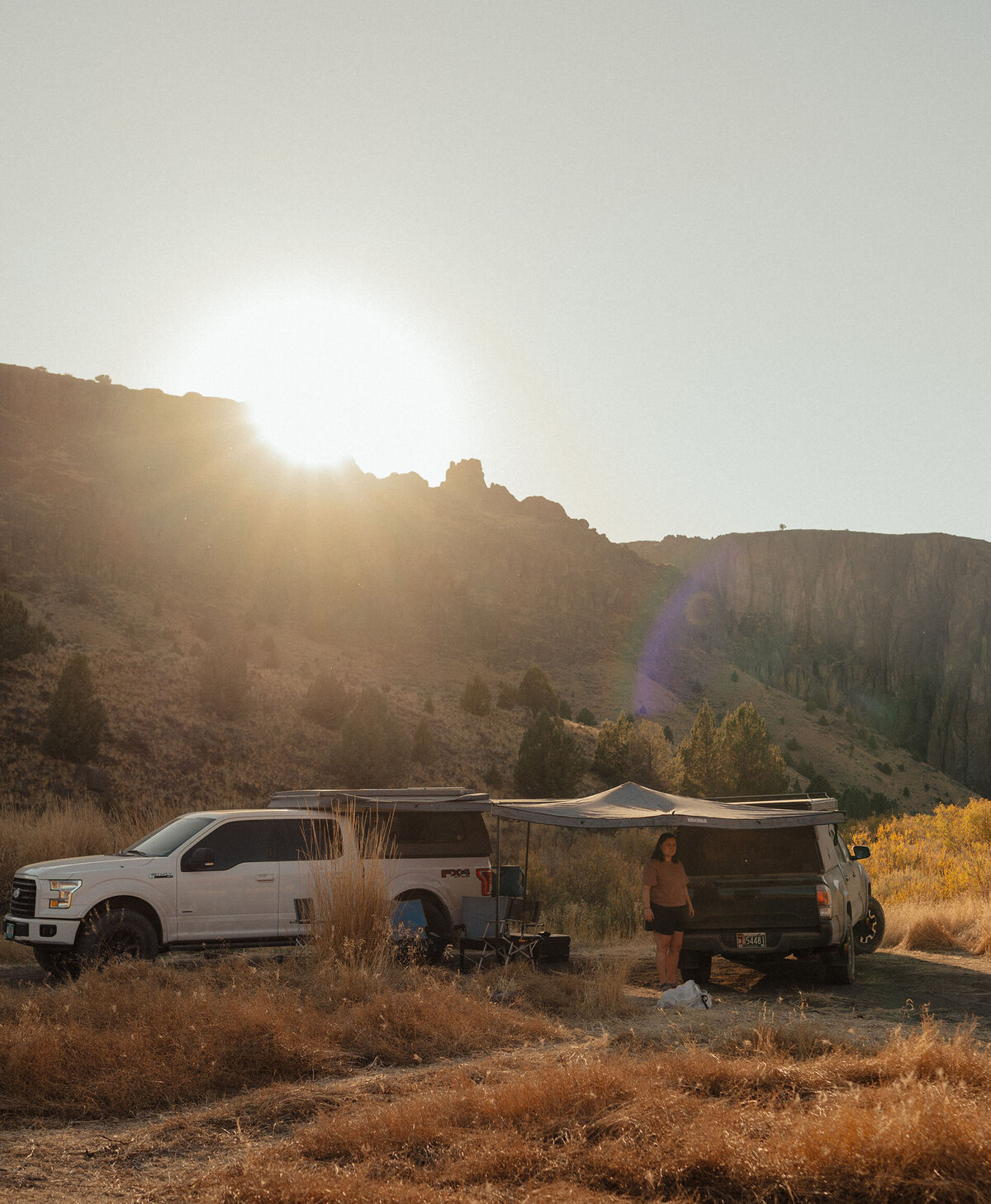 trucks with campers park in the golden sun while awaiting a private elopement in Moab, Utah