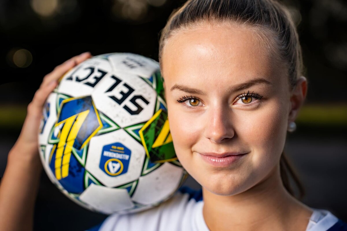 Sportporträtt av en fotbollsspelare med en boll på axeln