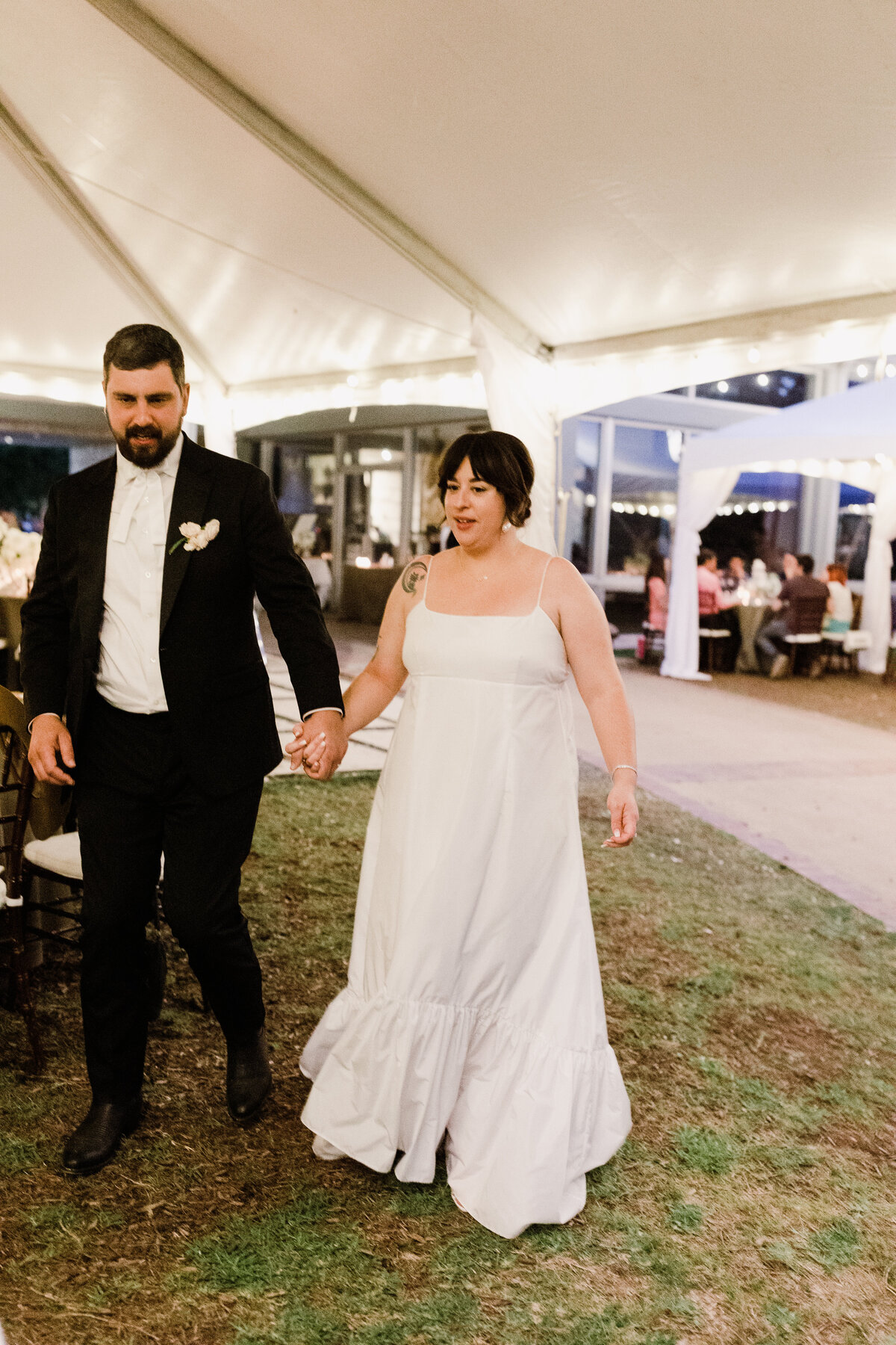 Bride and groom walking through wedding at Umlauf Sculpture Garden, Austin