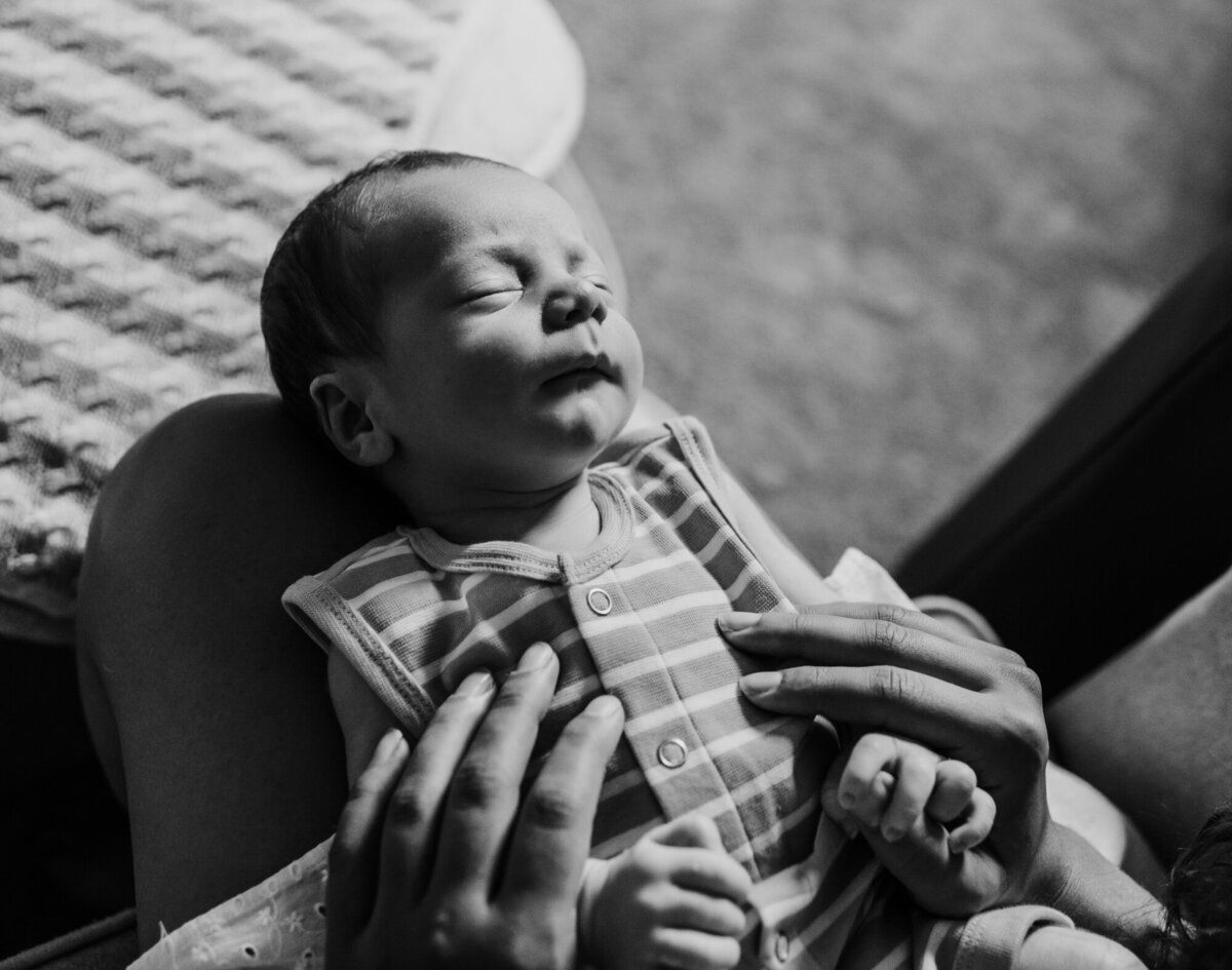 Newborn Photographer, Little boy on mom's lap sleeping.