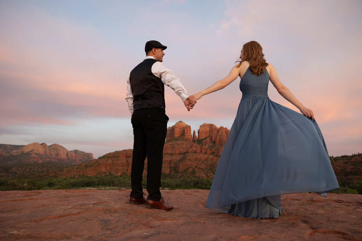 Couple standing against red rock backdrop during Sedona engagement session
